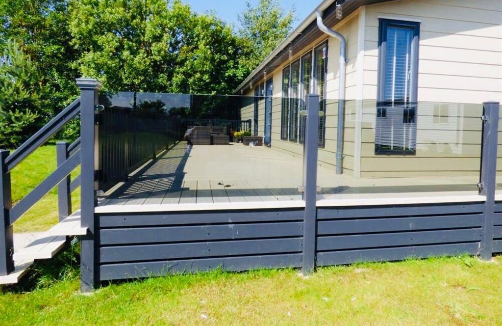 A luxury lodge with a wooden deck and a covered outdoor area.