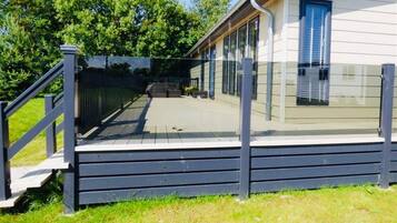 A luxury lodge with a wooden deck and a covered outdoor area.