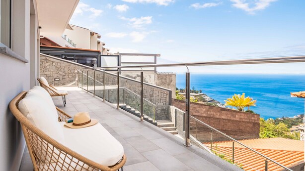 A balcony with wicker chairs, a hat, and a book, overlooking the ocean. - Villa Vellure by Homie (Funchal)