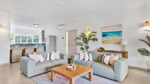 Un salon moderne avec deux canapés, une table basse en bois et une grande fenêtre.