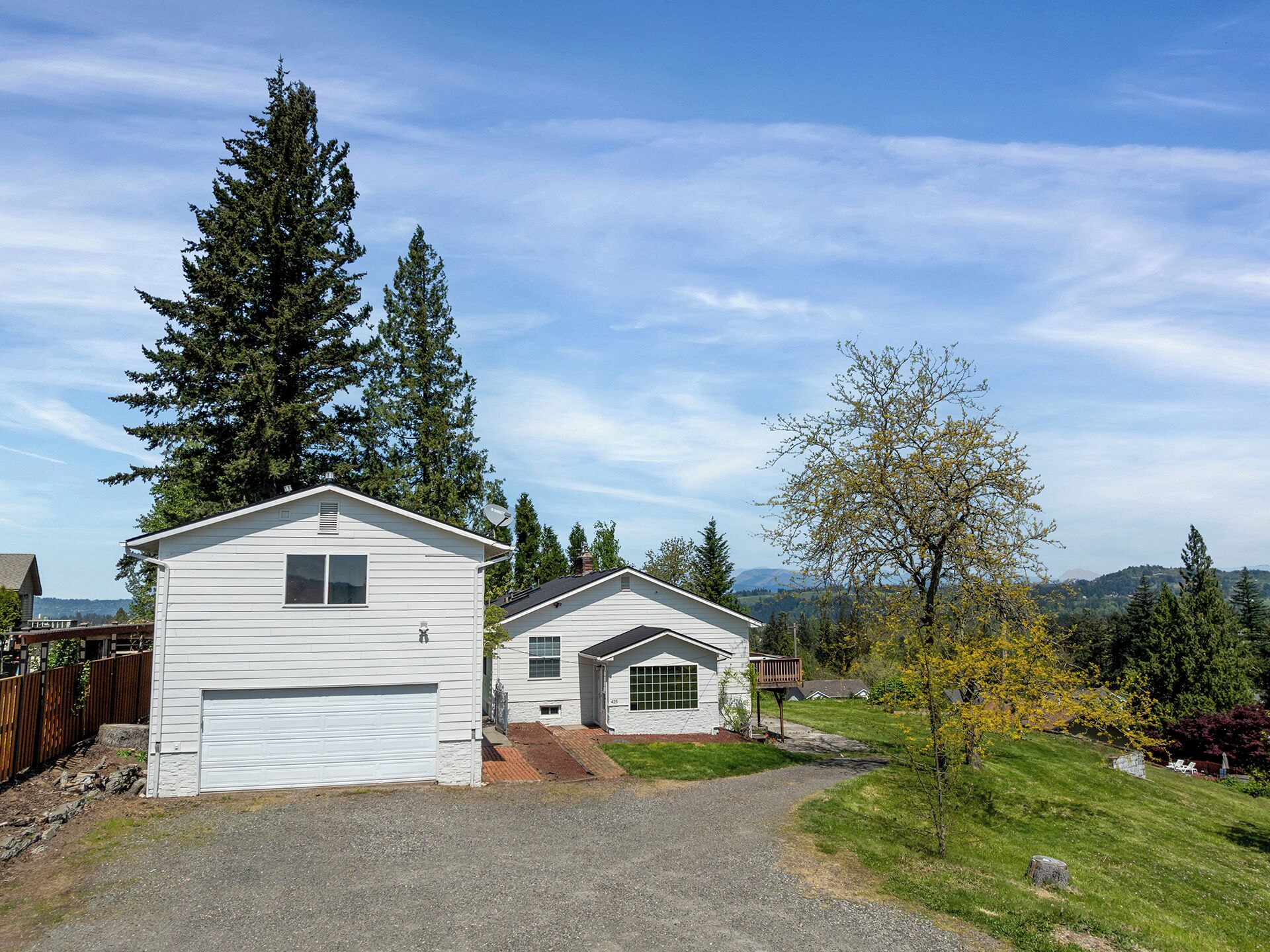 A two-story house with a garage, a small porch, and a driveway leading to the house.