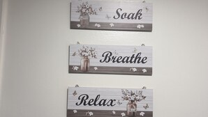 A wall with four wooden signs, each with a different word and a floral arrangement.