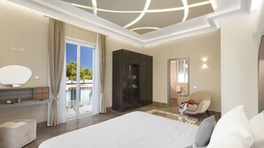 Une chambre d’hôtel moderne dotée d’un grand lit, d’une coiffeuse avec un miroir, d’une armoire et d’un coin salon comprenant une chaise et une petite table.