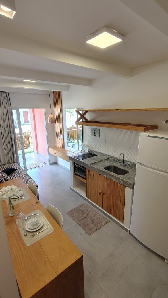 A modern kitchen with a built-in oven, a sink, and a refrigerator.