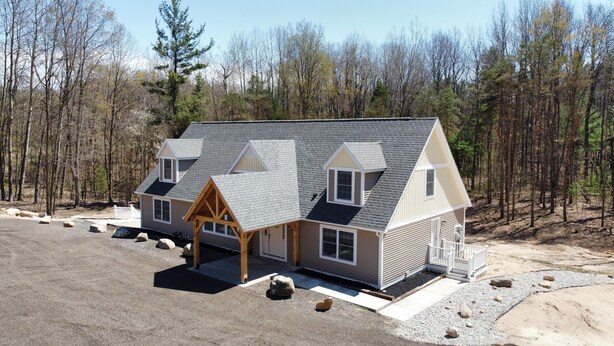 A two-story house with a gabled roof, a covered porch, and a gravel driveway. - Newly built secluded home, large game room, full RV hook-up (Mears)
