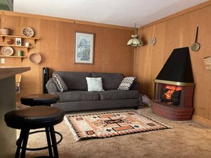 Relax in this inviting living space with a cozy sofa, fireplace, and warm ambiance.