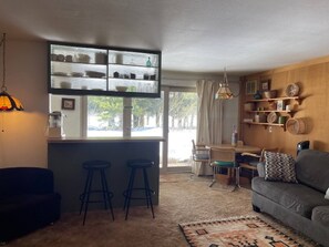 Relax in this inviting living space with a kitchen area, comfortable sofa, and dining table.