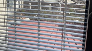 A view through metal bars with buildings and a road in the background. - Dara House (Plovdiv)