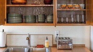 Een keuken met houten kastjes, een dubbele spoelbak en een broodrooster.