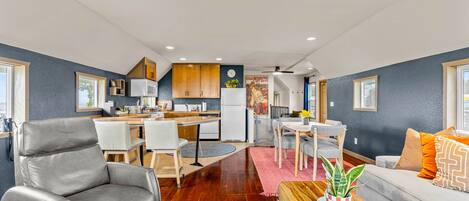 A modern living space with a dining area, kitchen, and seating area.