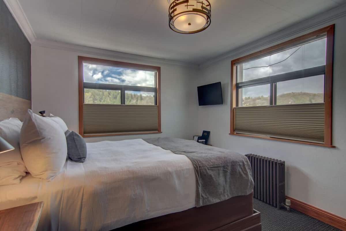 Cortinas blackout, tabla de planchar con plancha y ropa de cama