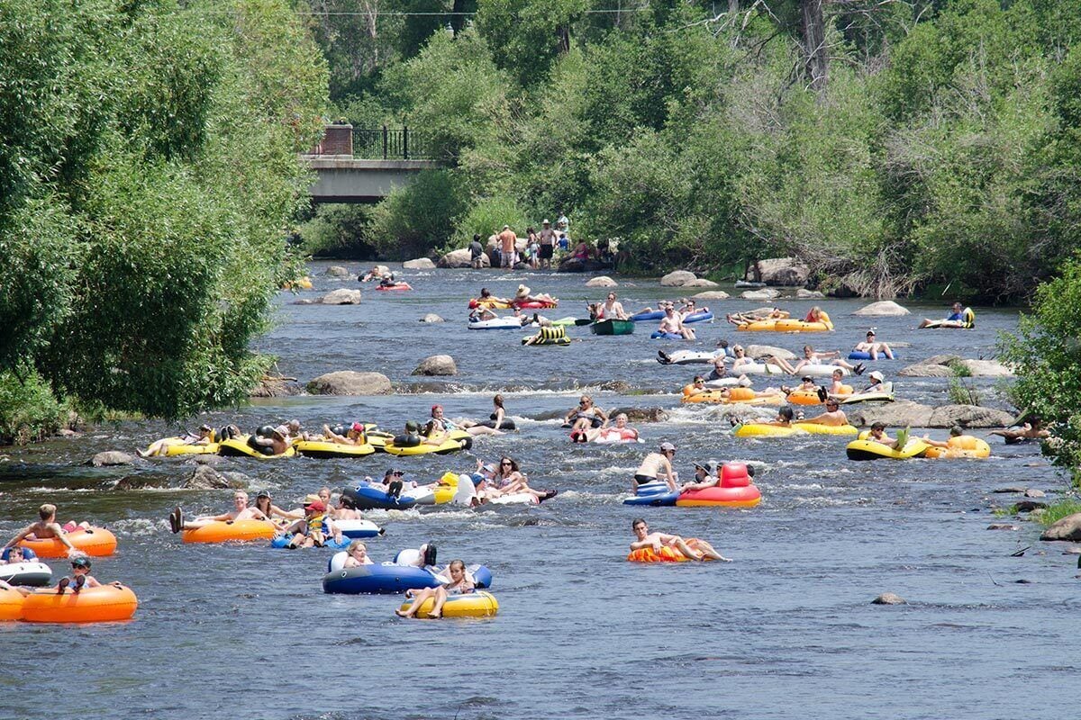Un río con varias personas flotando en balsas inflables de colores.