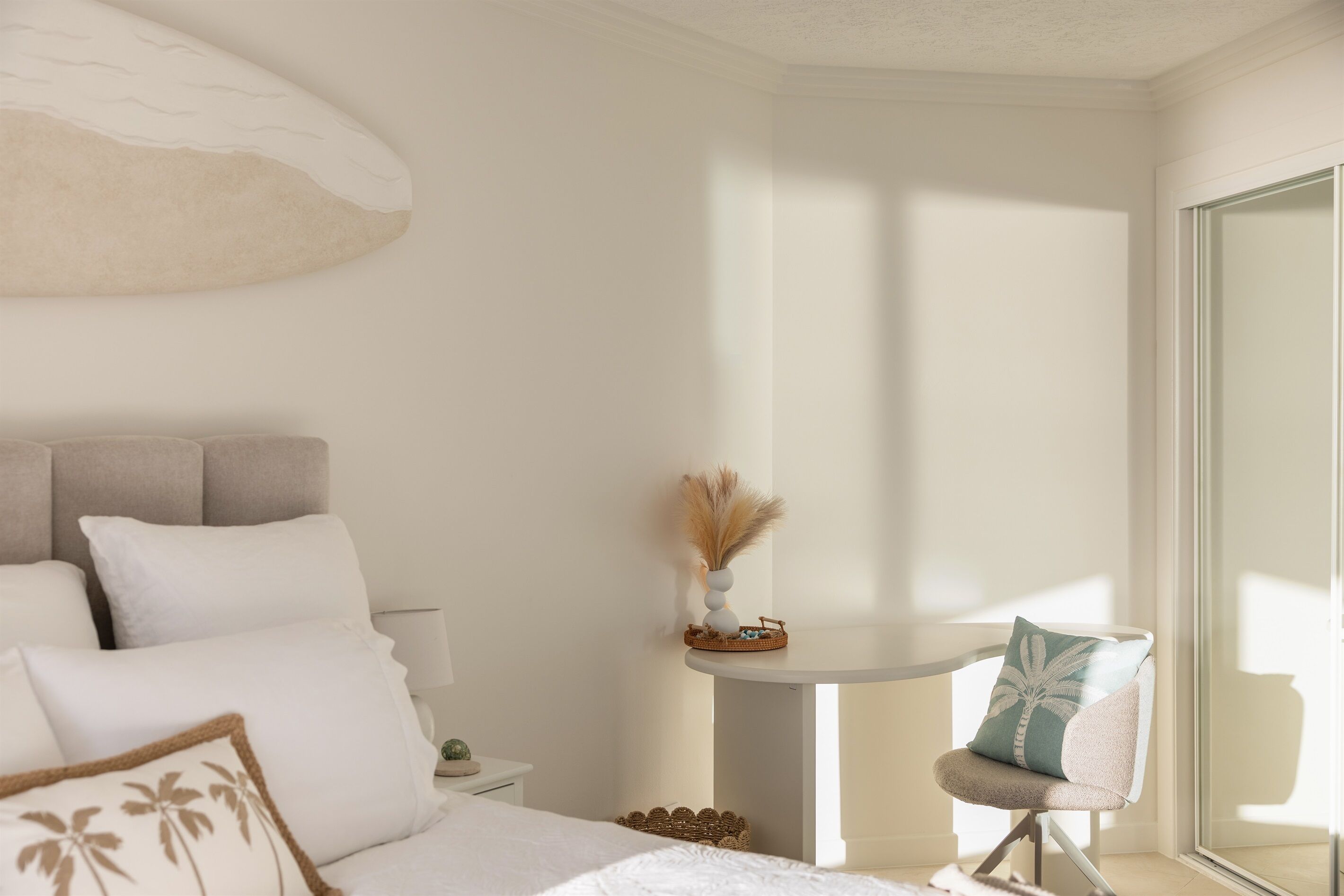 A bedroom with a bed, bedside table, and a chair.