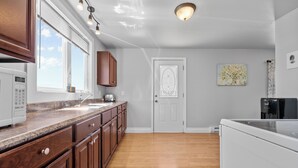 Una cocina con armarios de madera, una encimera, un refrigerador y una cafetera.