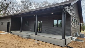 A modern building with a covered porch, large windows, and a flat roof.