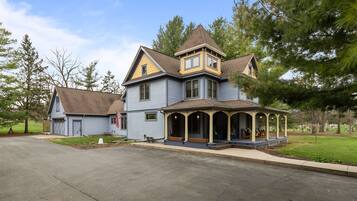 A large, two-story house with a prominent porch and a small attached garage.