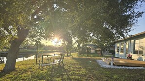 A park with a bench, a small pond, and a building with large windows. - Spacious 4-bedroom house in charming Rotonda West with WiFi, AC, canal front. (ROTONDA WEST)