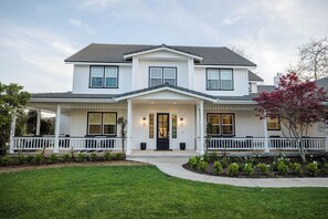 A two-story house with a front porch, a covered entryway, and a landscaped front yard.