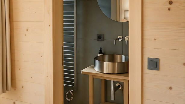 A wooden interior with a built-in sink, a mirror, and a towel rack. - Les Mayens d'Adrien (Mase)