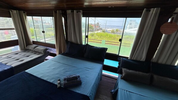 Ein Zimmer mit einem großen Bett, einer Couch und einem Vorhangfenster.