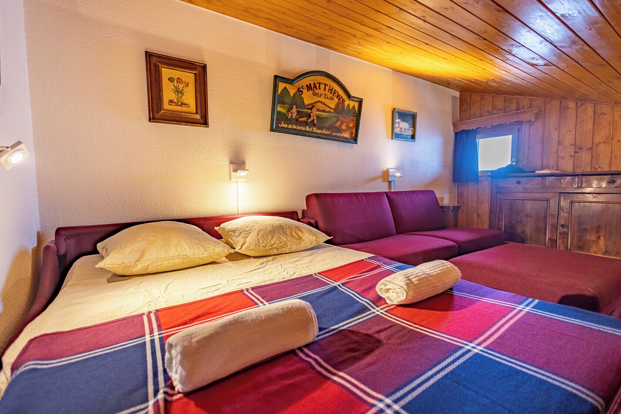 Ein Hotelzimmer mit zwei Betten, einer Holzbalkendecke und einem Schild an der Wand.