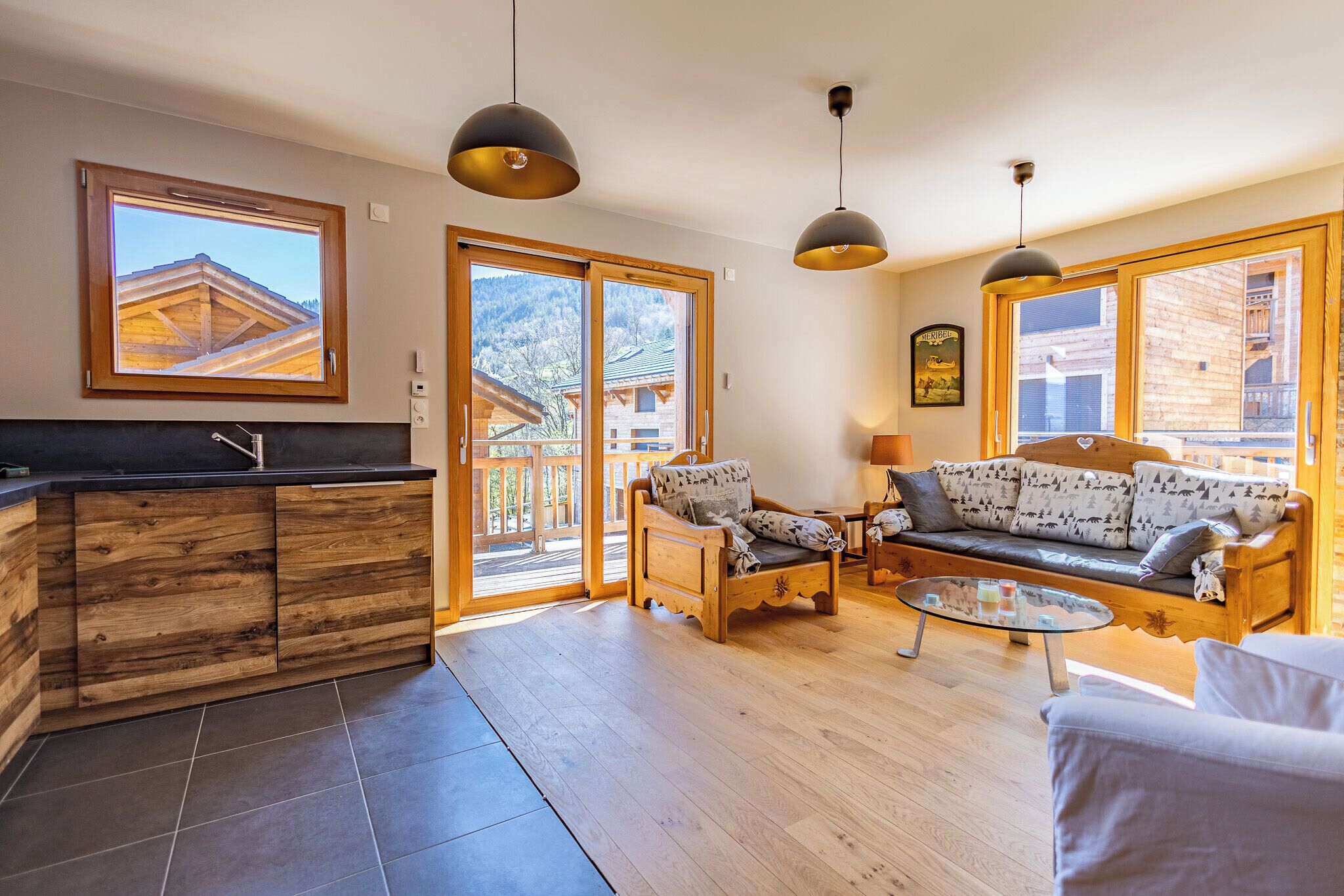 Amplia sala de estar con sofá de madera, mesa de centro de vidrio y un mueble de madera con lavamanos. Grandes ventanales ofrecen vistas al exterior.