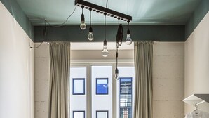 Een moderne slaapkamer met twee bedden, een bureau en een hangende lamp.