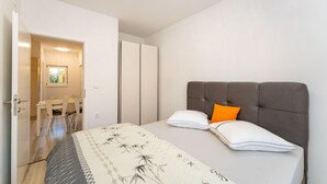 Un dormitorio con cama, armario y zona de comedor.