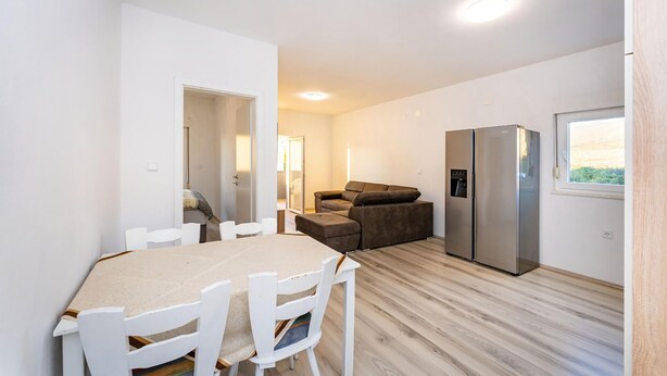 Un espacio habitable compacto con comedor, kitchenette y sofá.