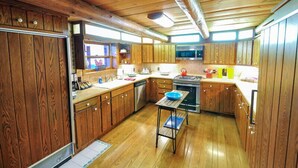 A kitchen with wooden cabinets, a microwave, a stove, and a sink.