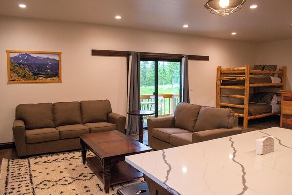 A cozy living room with a sofa set, a coffee table, a marble table, and a bunk bed.