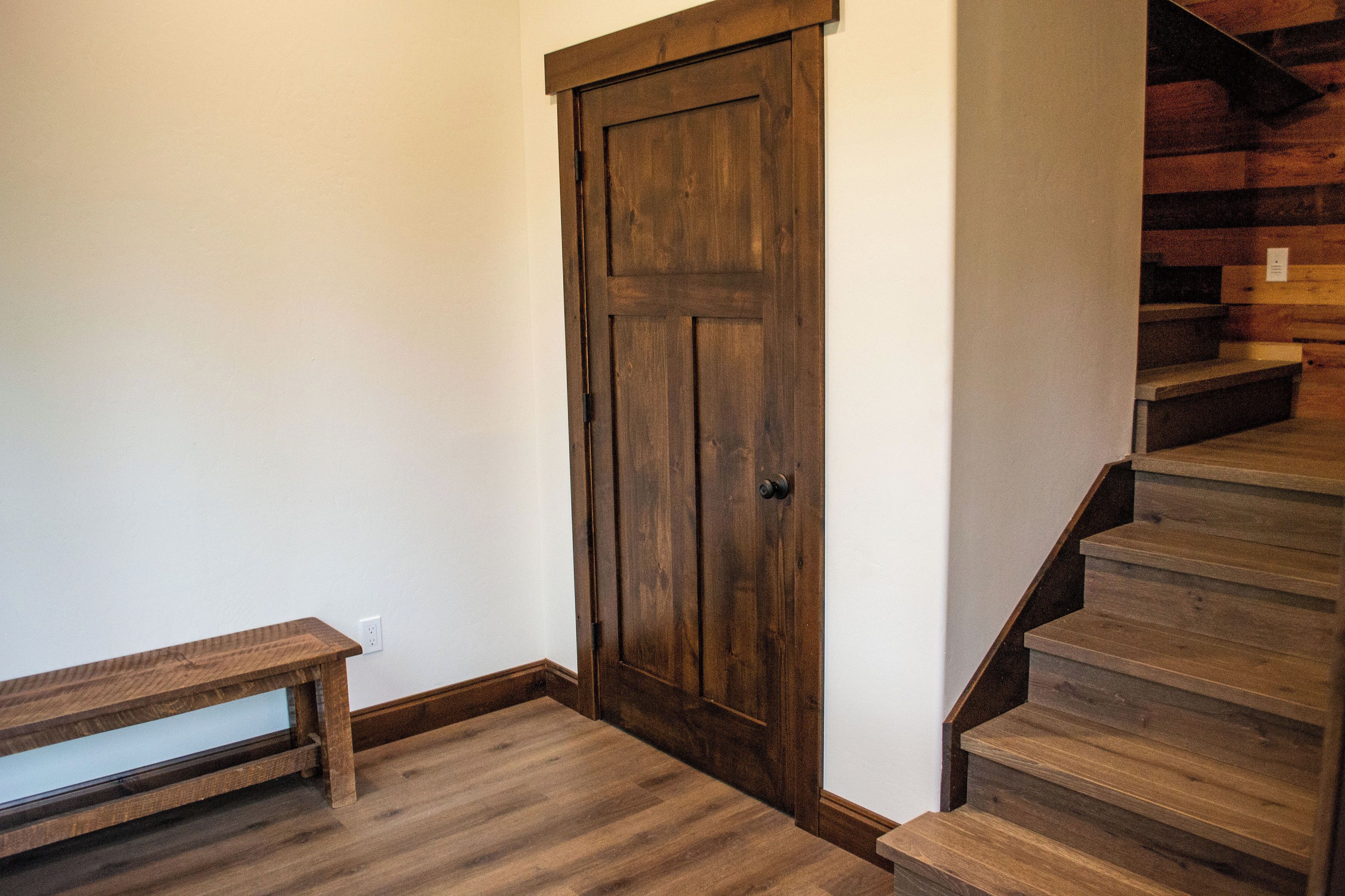 A wooden door, a wooden bench, and a wooden staircase.
