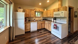 A kitchen with wooden cabinets, a refrigerator, a dishwasher, a microwave, and an oven.