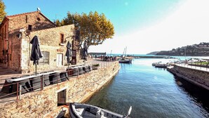 A stone building with outdoor seating and a view of the water. - Gorgeous apartment in Port-Vendres with WiFi (Port-Vendres)