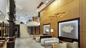 A modern lobby with a central staircase, seating areas, and a fireplace. - Marriott Executive Apartments Istanbul Investvadi (Sariyer)