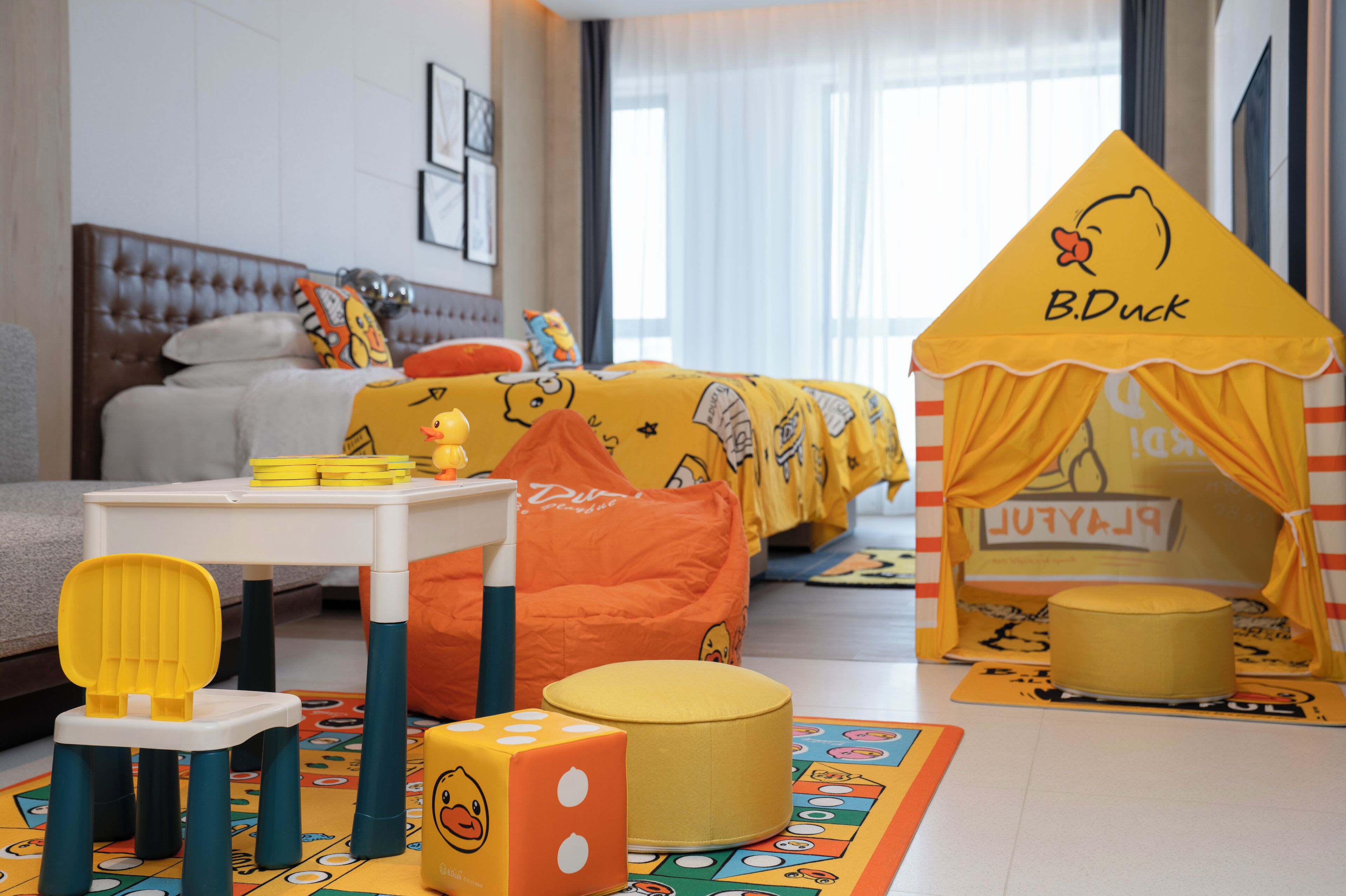 A children's play area with a bed, pillows, and a play tent labeled 'B.Duck'.