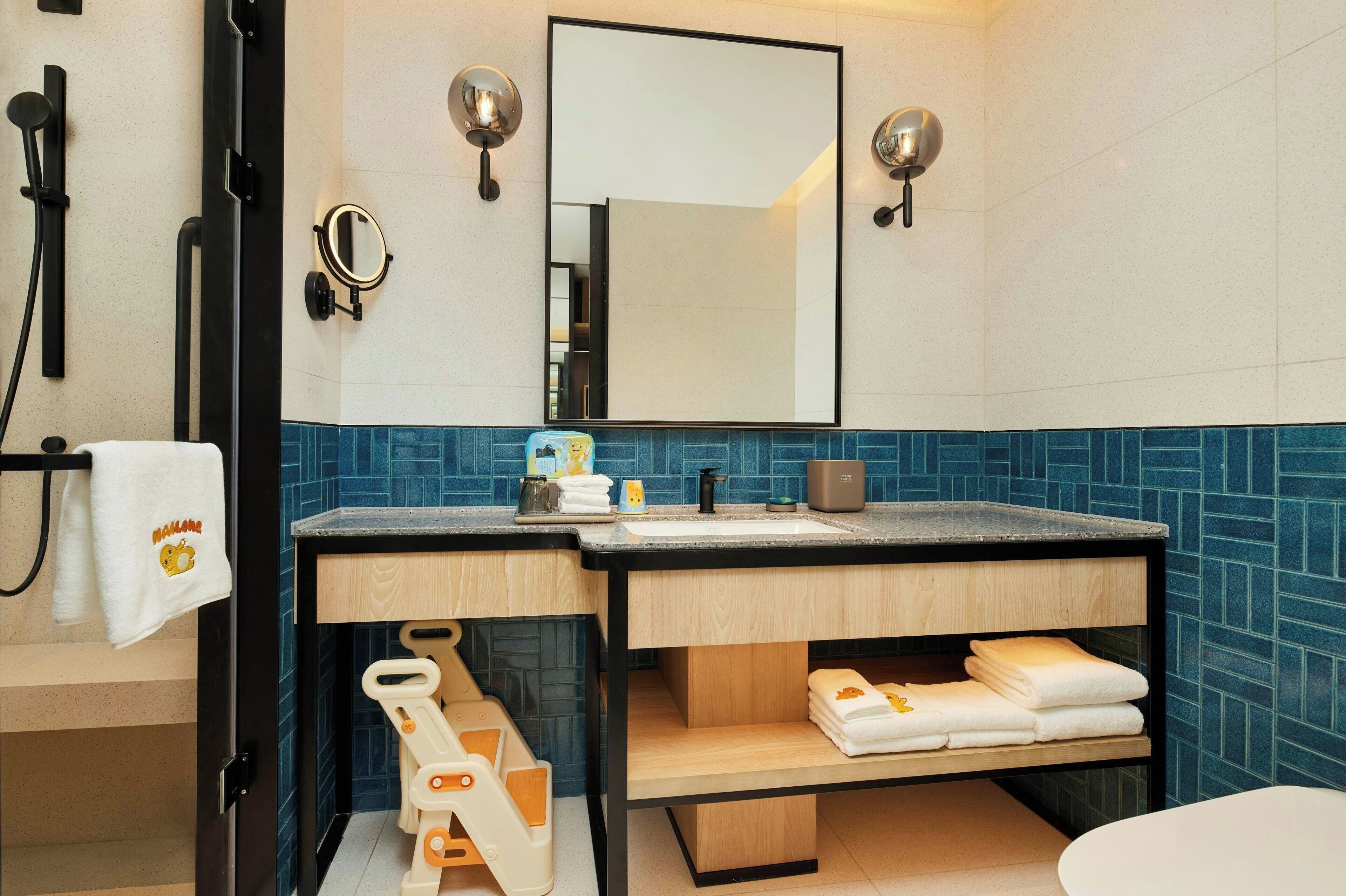 A bathroom with a wooden vanity, a sink, a mirror, and a towel rack.