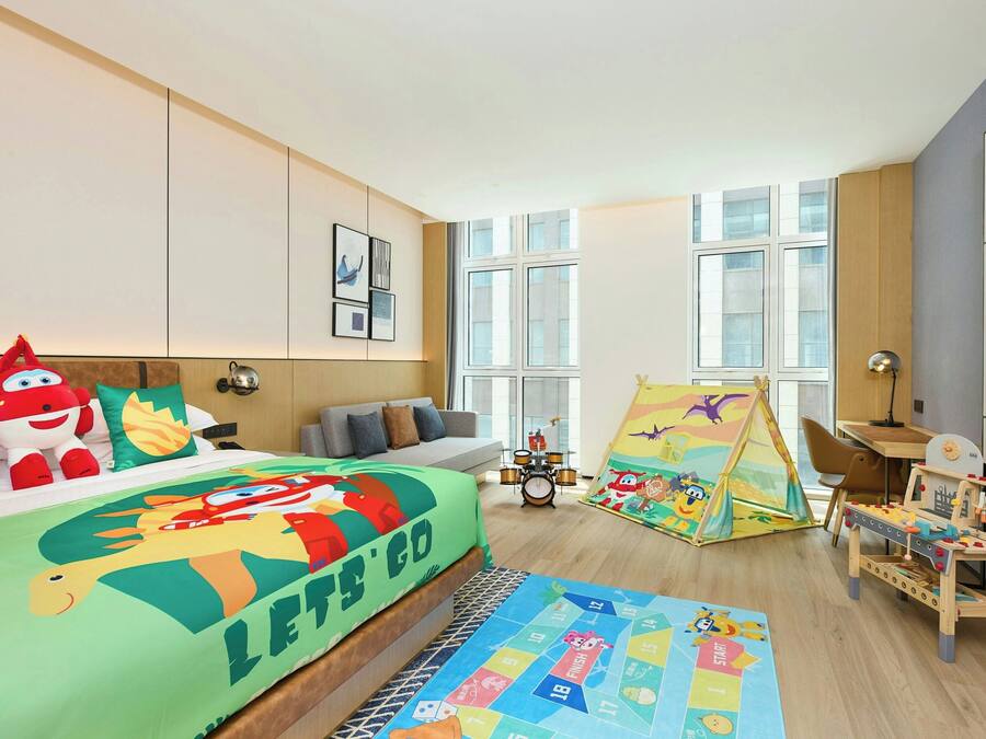A child's bedroom with a bed, a play area, and a window.