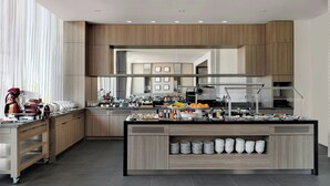 A modern kitchen with a central island, wooden cabinetry, and a breakfast bar.