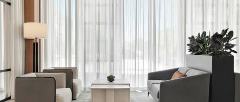 A modern living room with a sofa, armchairs, a coffee table, and a floor lamp.