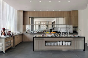 A modern kitchen with a central island, built-in appliances, and a large window. - Ac Hotel Bentonville (Bentonville)