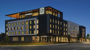 A modern hotel with a flat roof, multiple windows, and a well-lit facade.