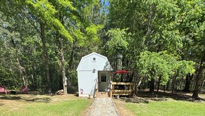 A pathway leading to a small, single-story building with a sloped roof, surrounded by trees. - Cozy fisherman cabin step from Lake Sam Rayburn (Etoile)