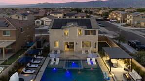 Une maison moderne à deux étages, dotée d’une piscine, d’un espace extérieur aménagé et offrant une vue sur le quartier environnant.