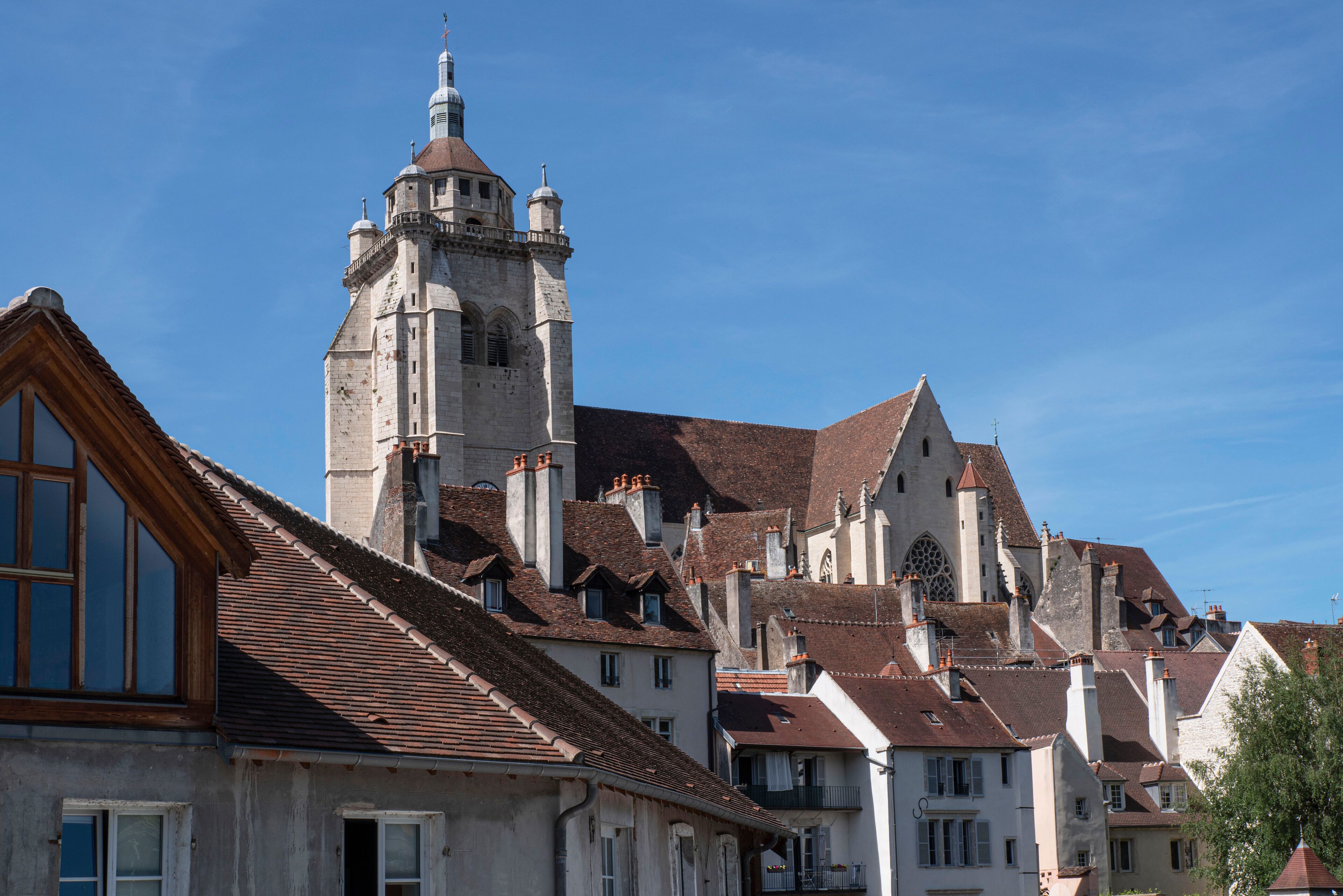 A historic building with a prominent tower and multiple chimneys.