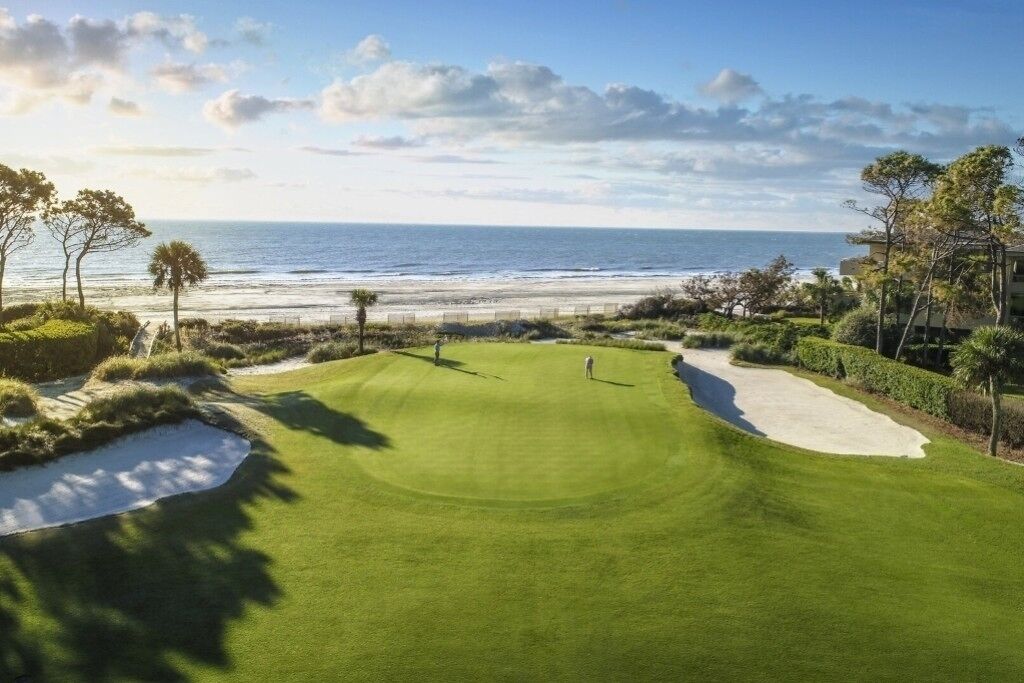 Un parcours de golf offrant une vue sur l’océan et la plage.