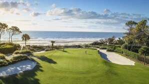 Un parcours de golf offrant une vue sur l’océan et la plage.