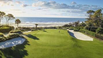 Un parcours de golf offrant une vue sur l’océan et la plage.