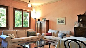 Ein Wohnzimmer mit zwei Sofas, einem Couchtisch und einem Esstisch.