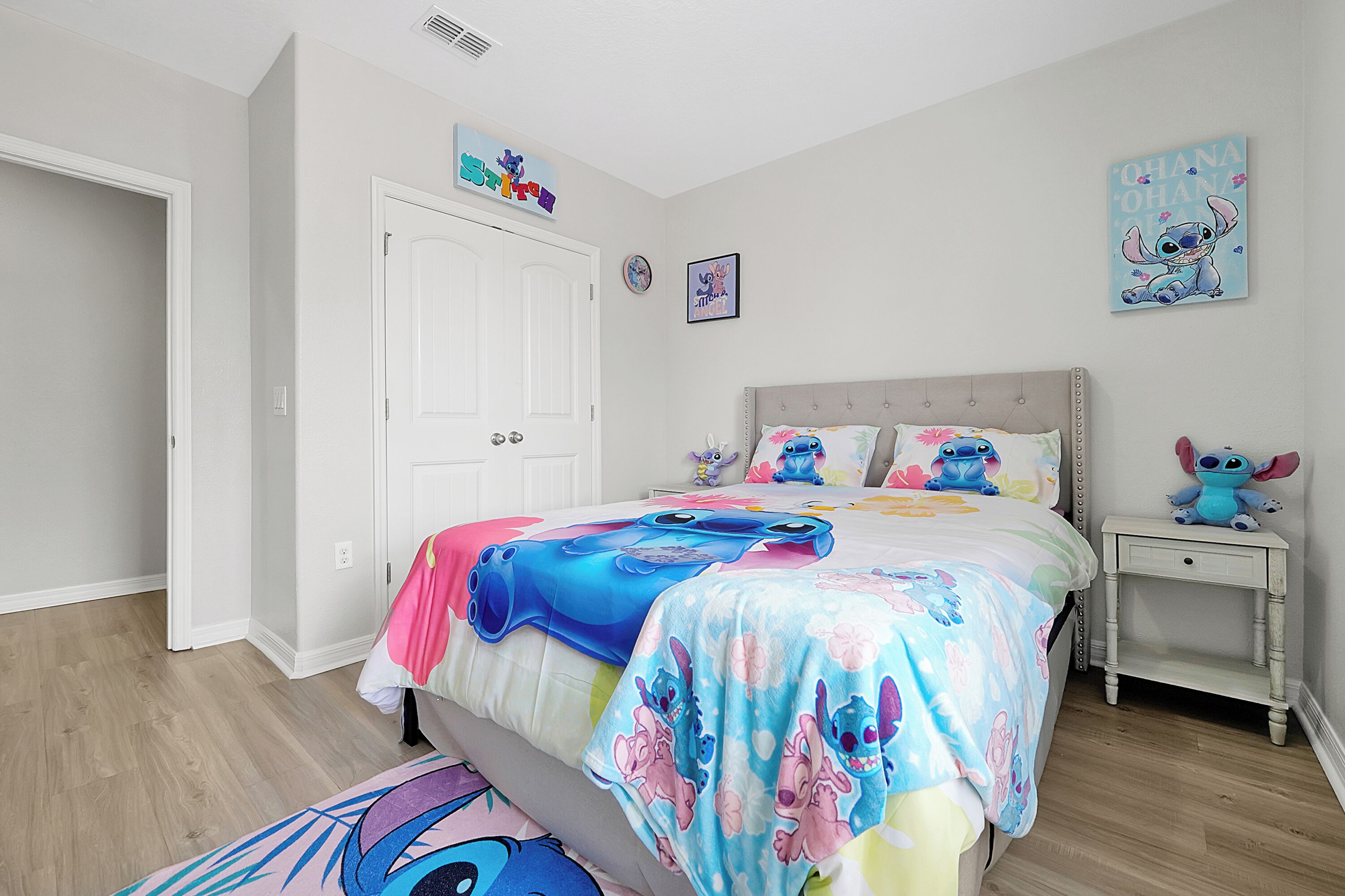 Un dormitorio con cama, mesita de noche y adornos en la pared.